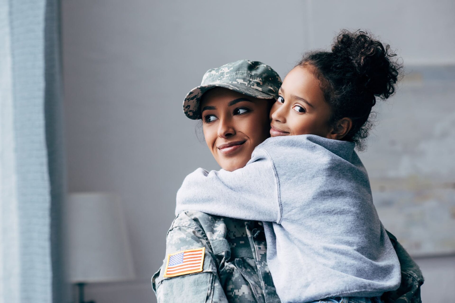 Mujer militar con una niña en brazos
