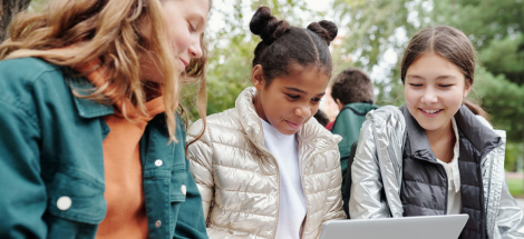 Alumnos de secundaria haciendo los deberes juntos con un portátil