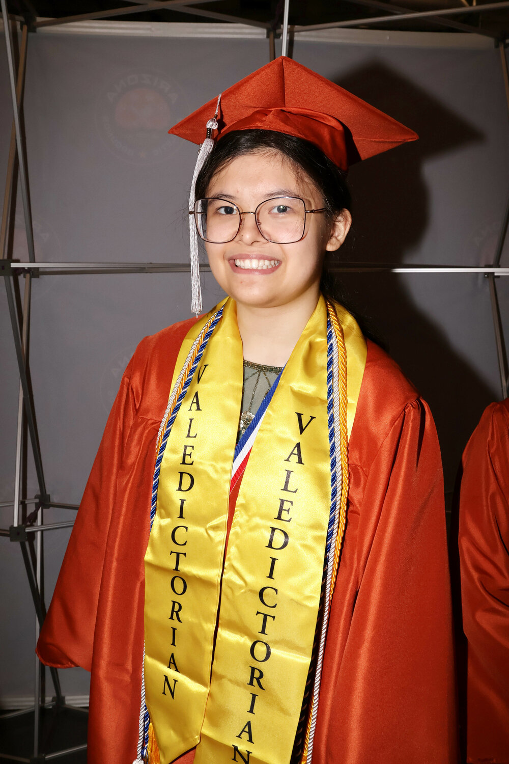 Grace Llames, mejor alumna de la promoción de 2026 de la Insight Academy of Arizona y arpista, con toga y birrete.