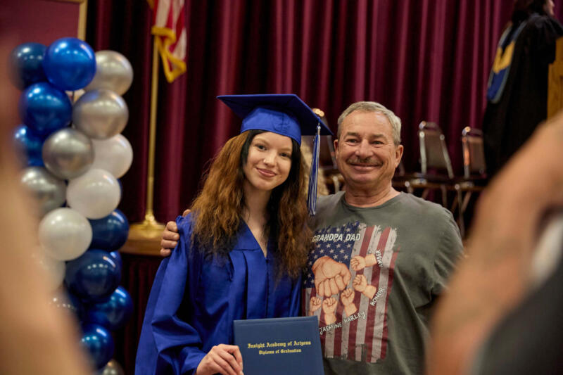 Una chica feliz tras su graduación junto a su padre