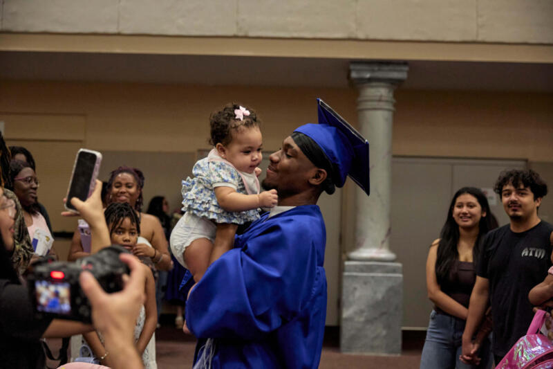 Un chico con un bebé en la graduación